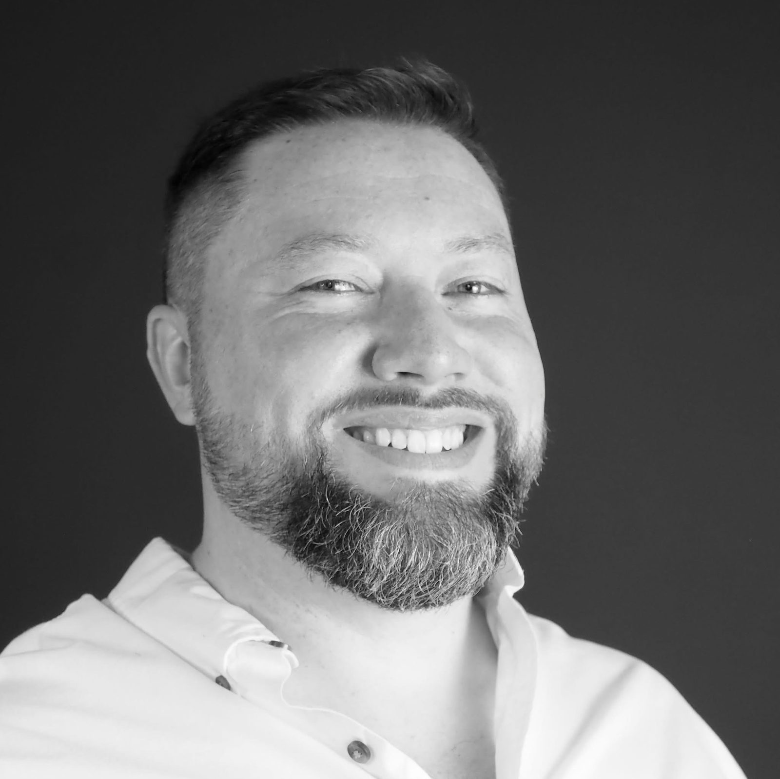 Dan Lawellin smiling in a black-and-white headshot